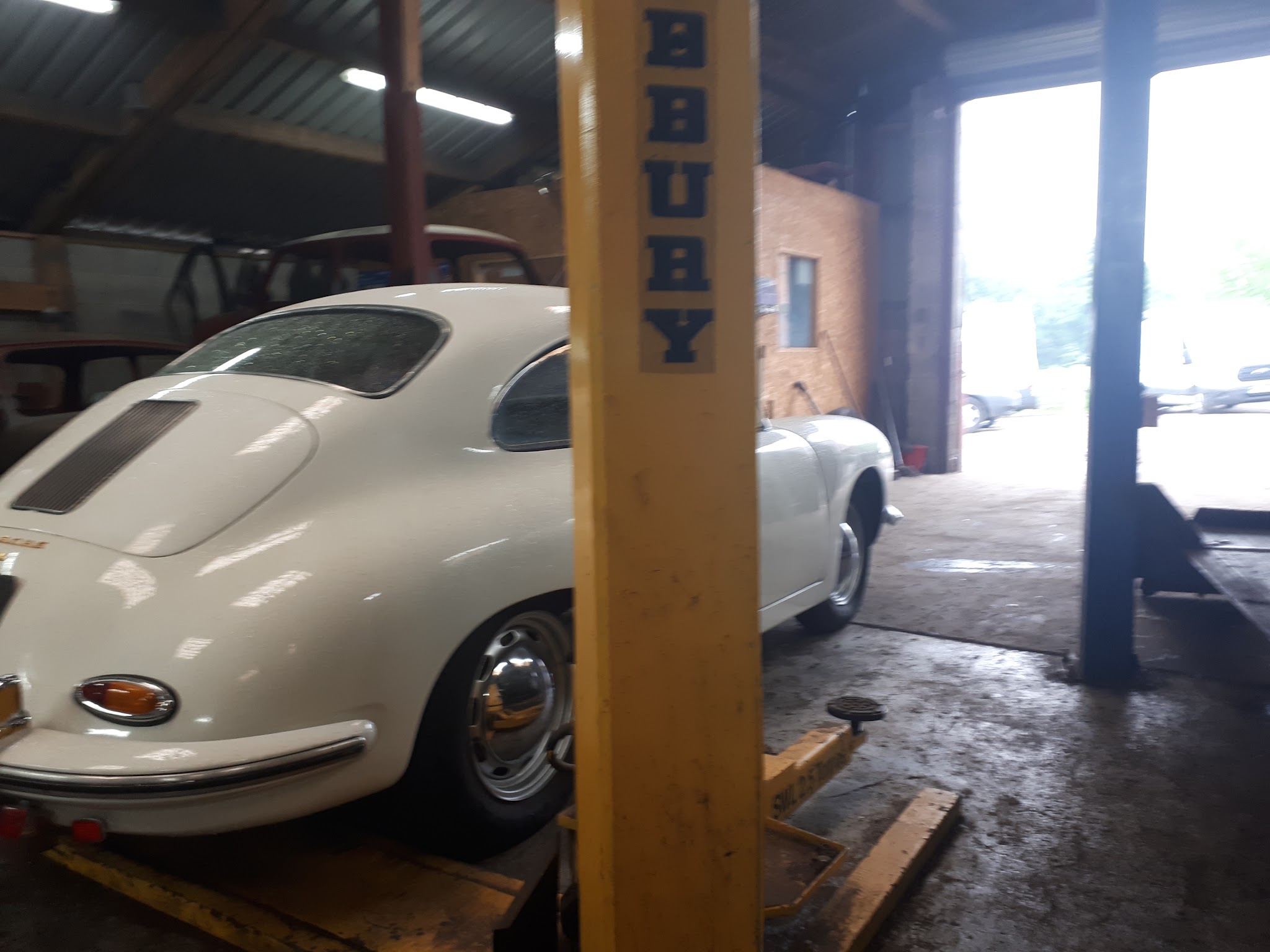 A white classic sports car on a lift